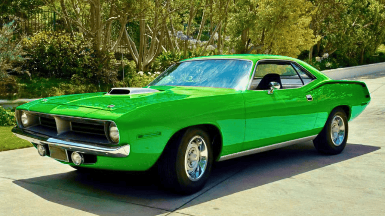 Classic muscle car restoration of a 1970 Plymouth Barracuda with vibrant red paint and chrome wheels